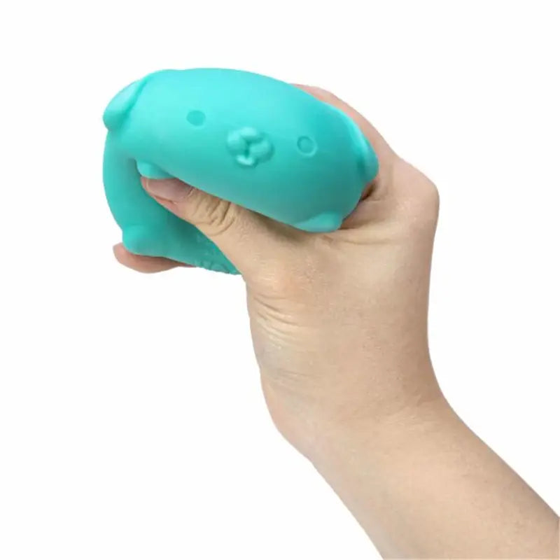 A teal-colored squishy sensory fidget toy shaped like a cat with simple facial features and quick rebound visible from the front.