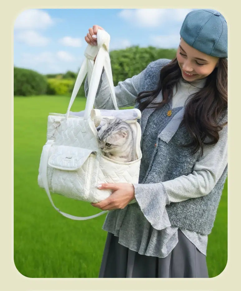 Bolsa transportín acolchada blanca para mascotas con bolsillo frontal y correa de hombro ajustable, diseñada para gatos y perros pequeños.