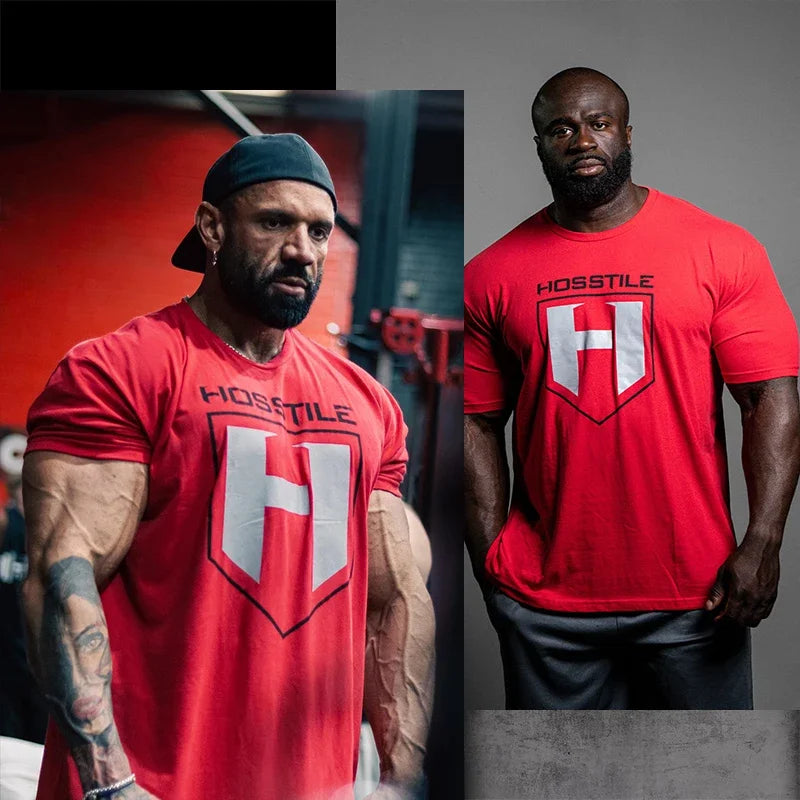 Rotes Herren-Cotton-Fitness-T-Shirt mit kurzen Ärmeln, mit einem weißen und schwarzen Wappensymbol sowie dem Wort hosstile darüber, ausgelegt für Activewear.