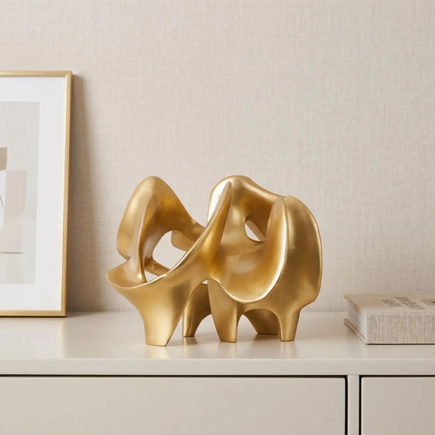 resin decorative item featuring a golden abstract sculpture with smooth flowing curves and a polished metallic finish