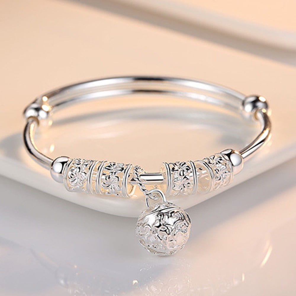 Bracelet jonc à billes grelots en argent sterling, orné d’une gravure florale détaillée sur des perles cylindriques et d’une breloque sphérique assortie, méticuleusement travaillée.