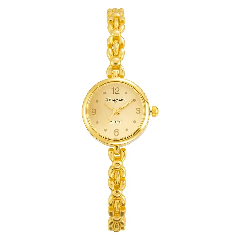 Gold ladies bracelet watch with a small round gold-toned quartz dial and an elegant chain-link bracelet featuring minimalist numerals at 12, 3, 6, and 9.