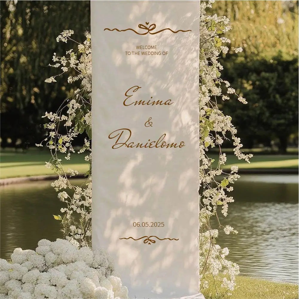 panneau de bienvenue de mariage personnalisé en tissu de couleur ivoire, haut et de forme rectangulaire, avec une élégante écriture cursive dorée et des ornements décoratifs.
