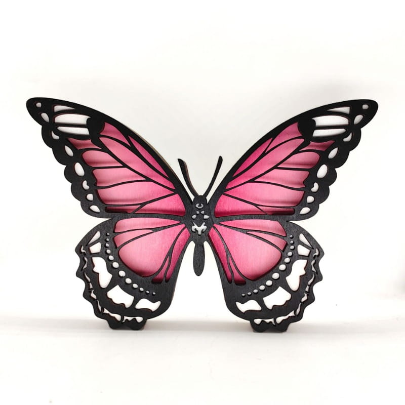 Wooden butterfly led light tabletop decor in pink and black with intricate cut-out wing patterns.