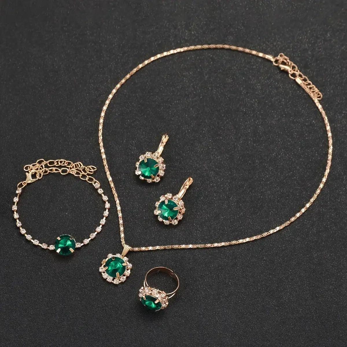 Emerald green quartz crystal jewelry set for women featuring a centerpiece necklace with gold-toned chain and matching earrings bracelet and ring.