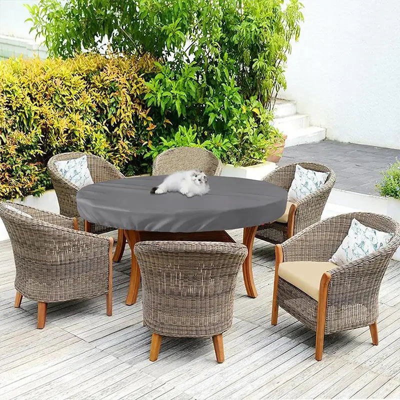 Funda de mesa de jardín al aire libre redonda impermeable en gris, elaborada con tejido suave resistente a las inclemencias que cae de forma uniforme sobre el comedor.