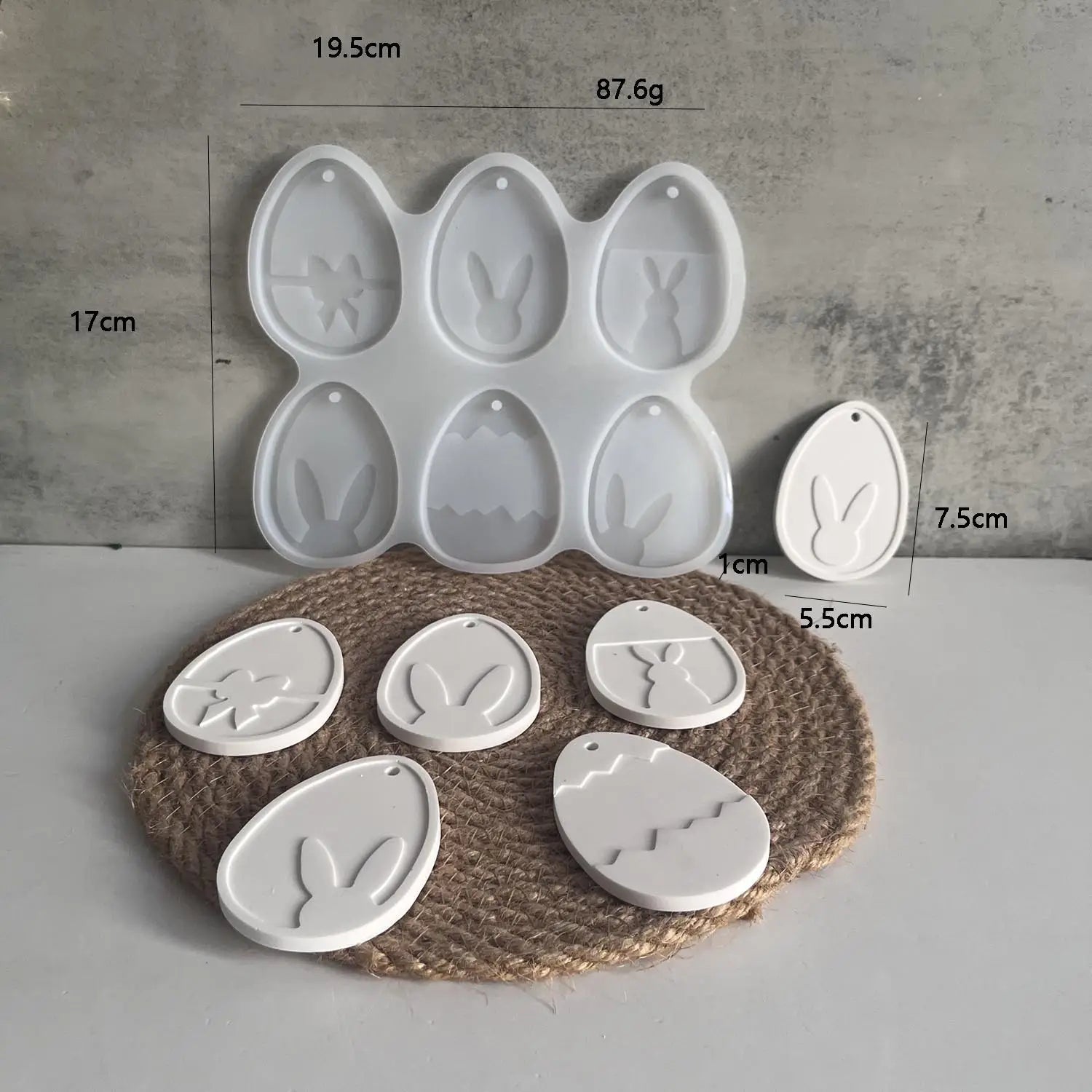 White ceramic easter egg-shaped ornaments featuring bunny and floral designs made using an Easter bunny silicone resin pendant mold.