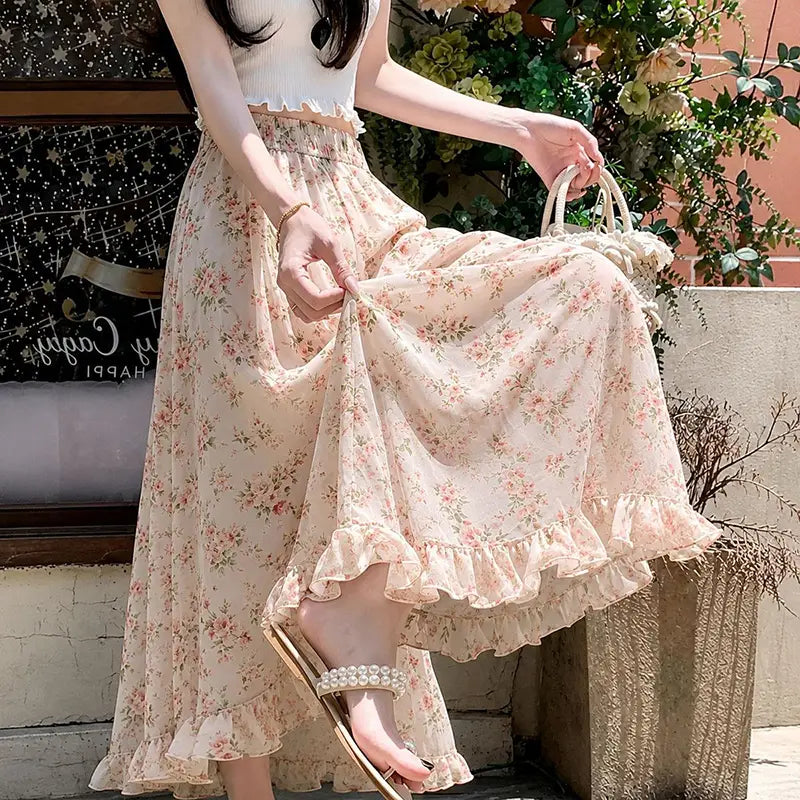 Ein fließender Maxirock in hellem Hellrosa mit floralen Motiven mit feinem Volantabschluss und elastischem Bund, entworfen als Sommerhose mit weitem Bein für Damen