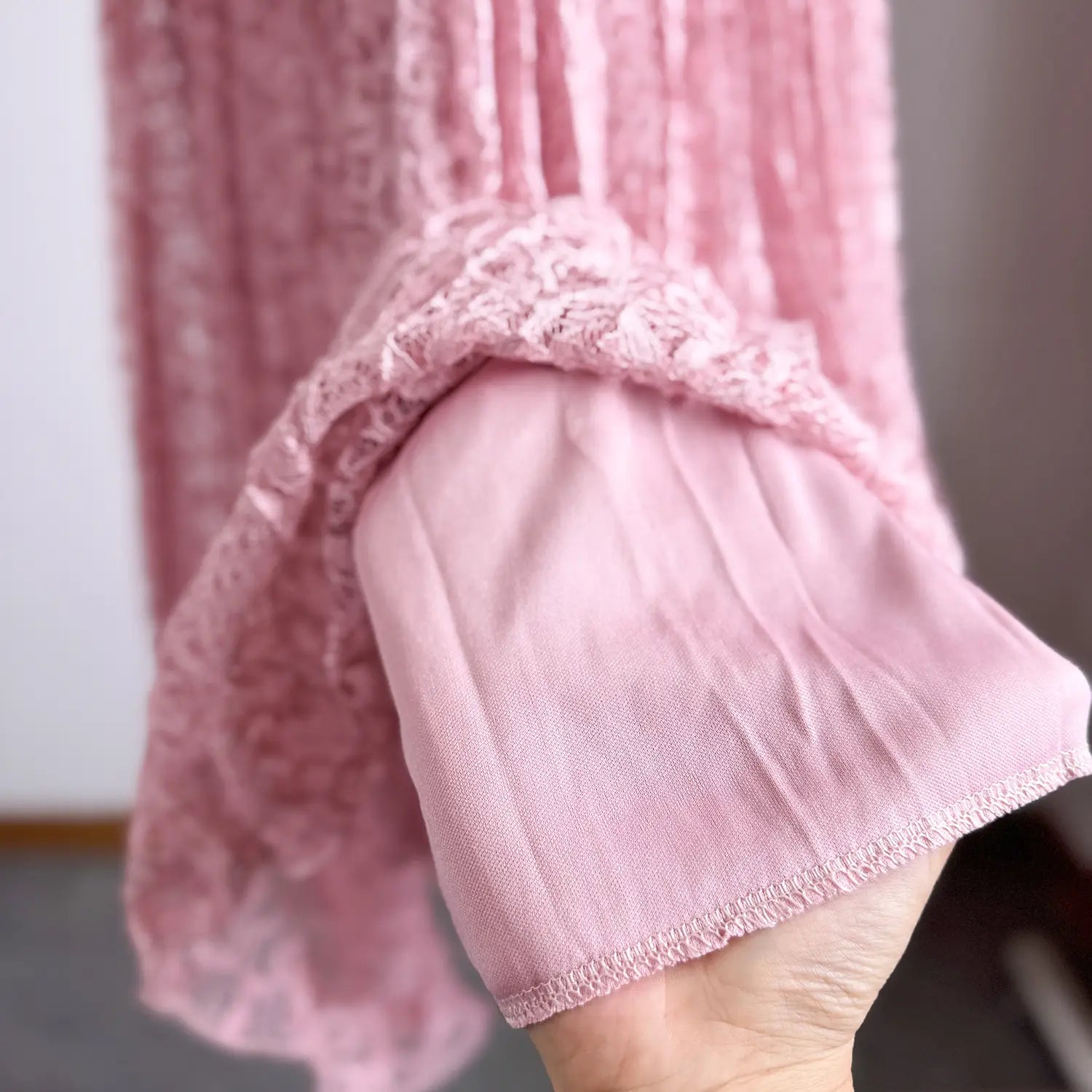 a delicate pink lace-trimmed sleeve with soft pleated fabric detail on a high waist pleated midi skirt y2k streetwear.