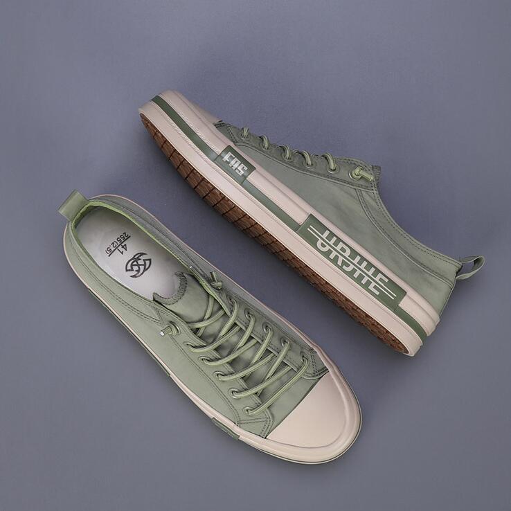 Baskets décontractées en toile pour hommes vert menthe, avec une coque en caoutchouc blanc et une semelle, présentant une discrète bande de logo sur le côté, conçues comme des chaussures d’été légères.