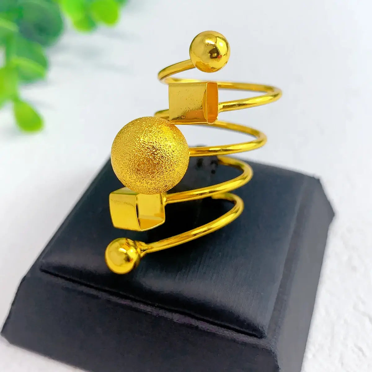 24k gold plated dubai spiral ring for women featuring a textured sphere, polished cubes, and spherical accents in a golden finish.