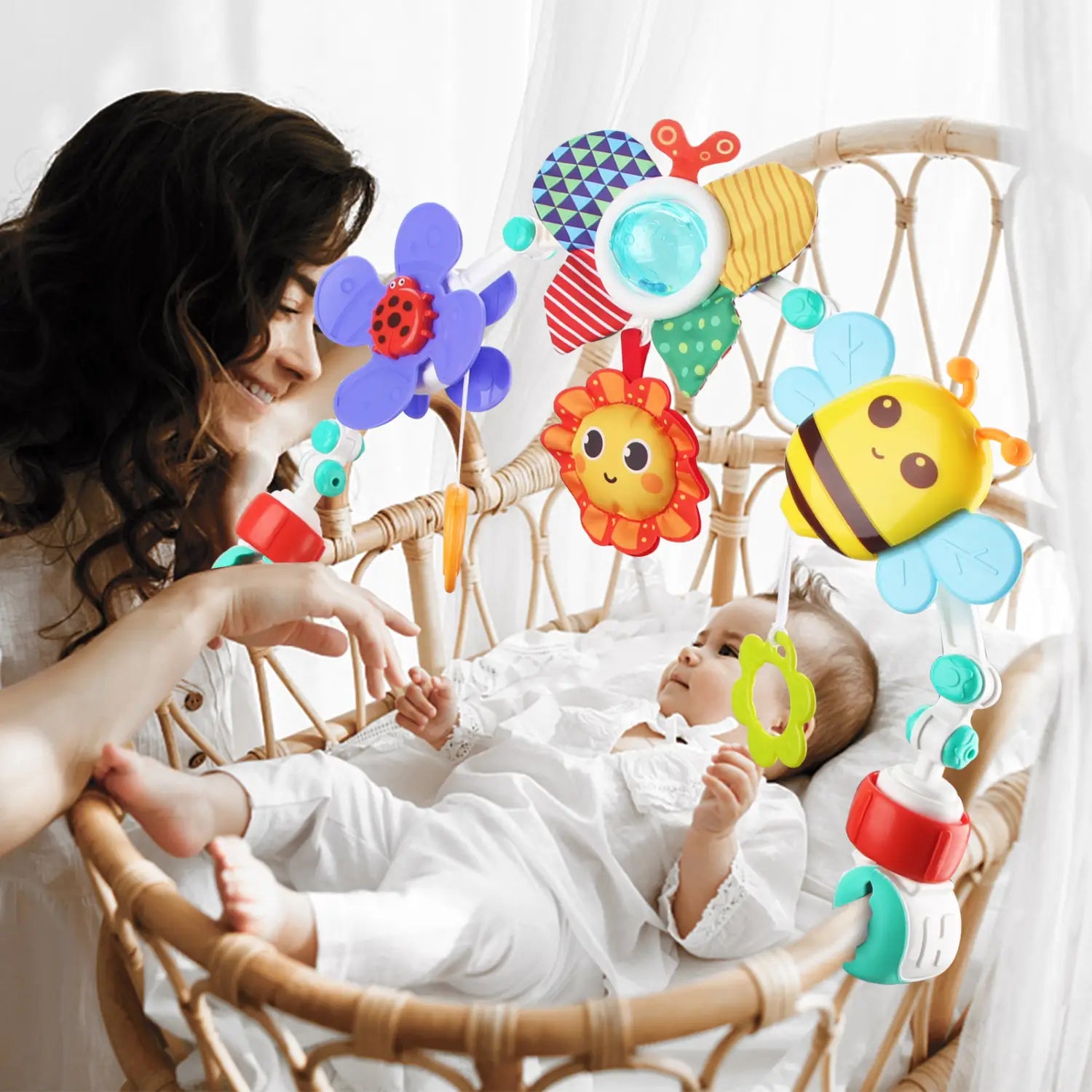 Mobile coloré en peluche d’insectes et de fleurs, à textures douces et motifs lumineux, suspendu au-dessus d’un bébé dans un berceau en osier, dans le cadre des jouets d’arche pour poussette de bébé du centre d’activités marin