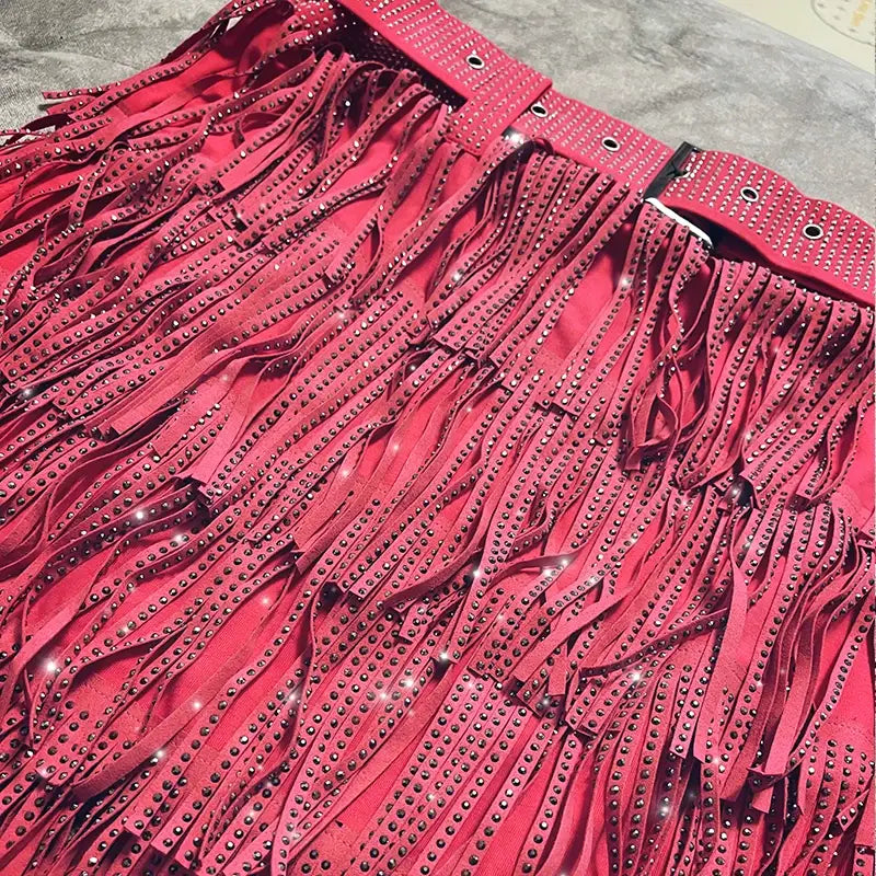 Mini-jupe taille haute rouge vif en suède à franges, ornée de rangées de strass noirs scintillants le long des franges et de la ceinture.
