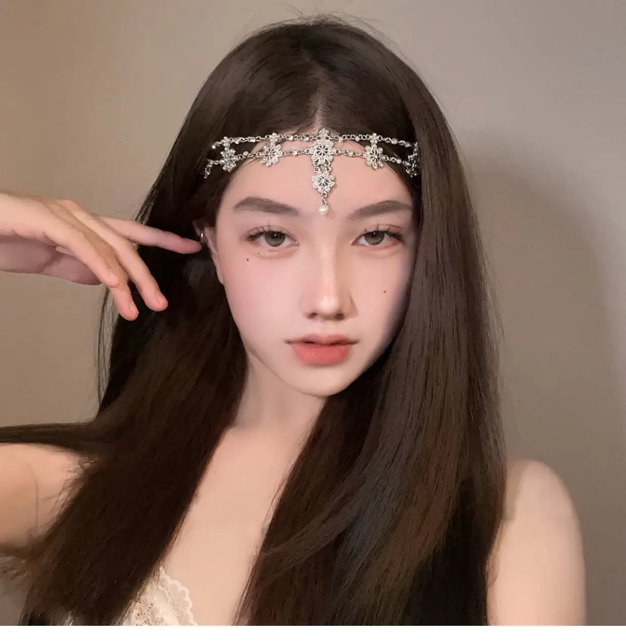 赤い宝石のゴールドのデザインにおけるスタイルとして、きらめくクリスタルの花と中央に揺れるペンダントをあしらった、繊細なシルバーの前髪チェーンヘアペンダントです。