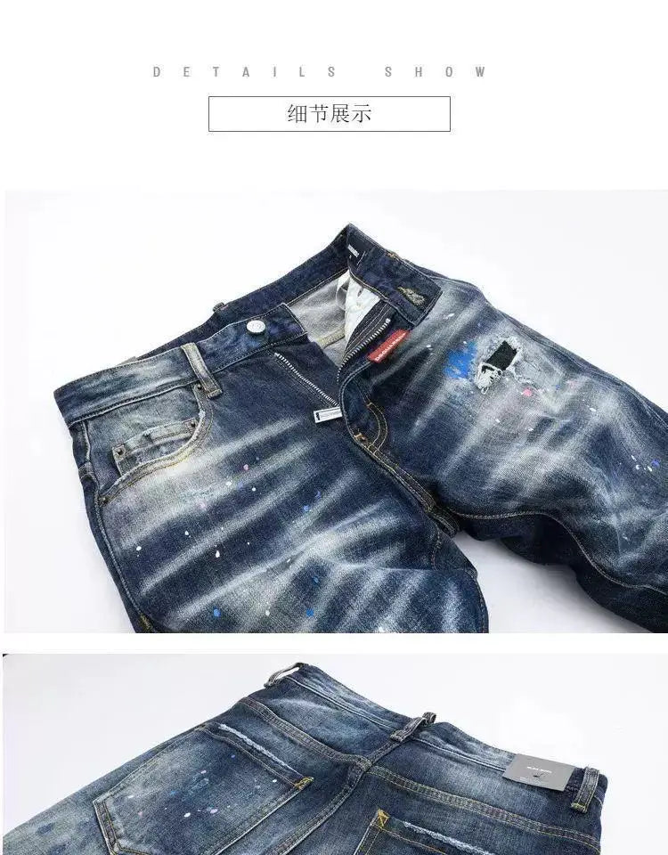 Männer-Farbspritzer-Jeans in gerader Passform aus Denim in abgenutztem Dunkelblau mit weißen Farbspritzer-Akzenten und einem roten Zipper-Anhänger.