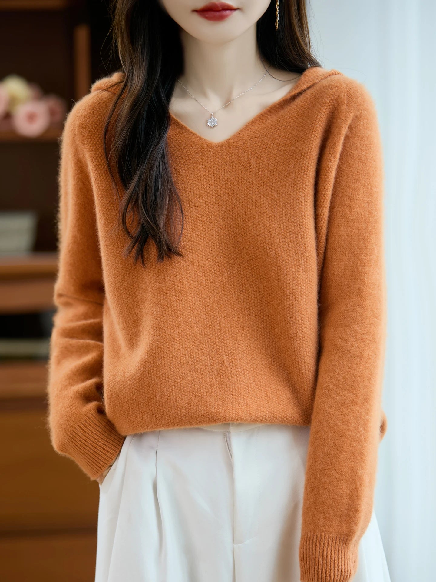 Warm orange pure wool hooded pullover sweater with a soft textured knit fabric and ribbed cuffs.