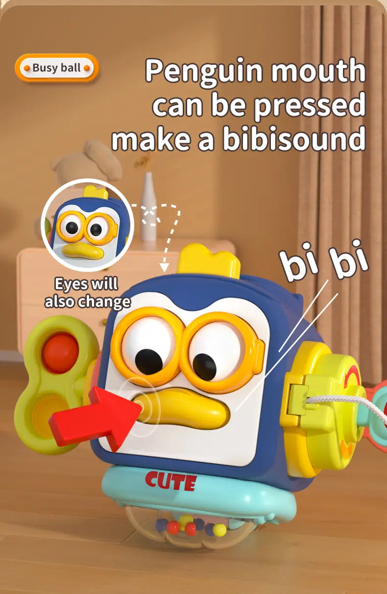Jouet de voyage cube d’occupation Montessori en plastique bleu et jaune, en forme de pingouin pour bébé, avec un visage souriant, des boutons colorés et des caractéristiques interactives.