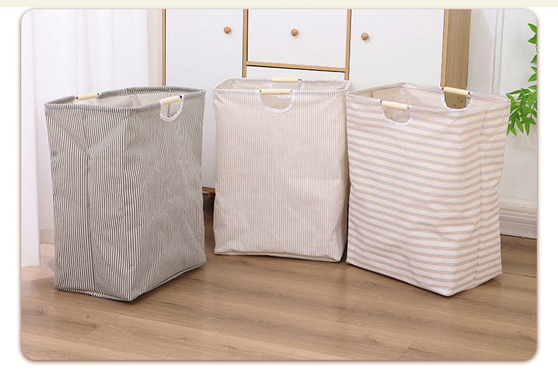 Drei gestreifte zusammenklappbare Wäschekörbe aus Canvas für Schmutzwäsche mit Holzgriffen in Grautönen und Beige, entworfen als Schmutzwäsche-Produkt mit praktischen Aufbewahrungs- und Tragbarkeitsfunktionen