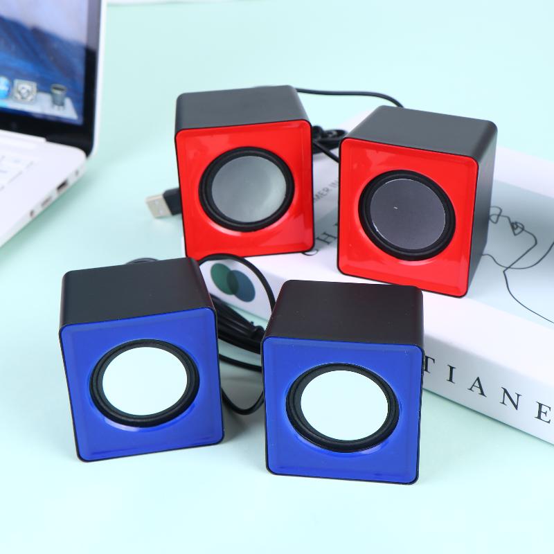 Set of four compact cube-shaped usb desktop speakers in vibrant red and blue with black accents featuring circular drivers for stereo audio computer system use.