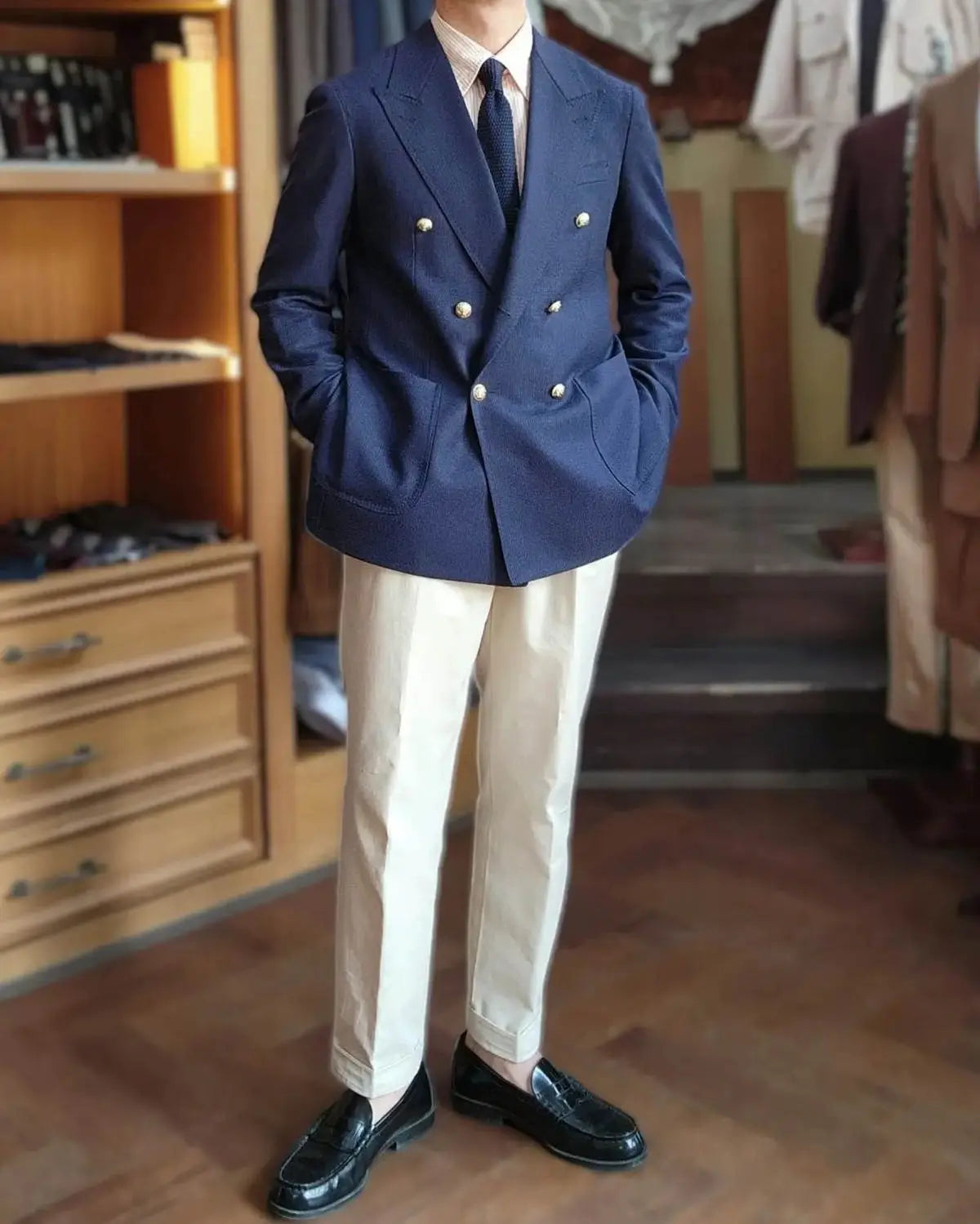 Veste de smoking bleu marine à double boutonnage avec fermeture boutonnée argentée, conçue pour la tenue du marié.