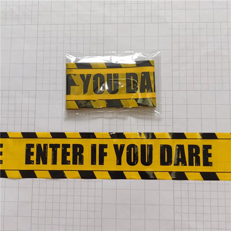 Halloween caution tape spooky party warning barrier features yellow and black caution tape with bold black text reading enter if you dare wrapped in clear plastic.