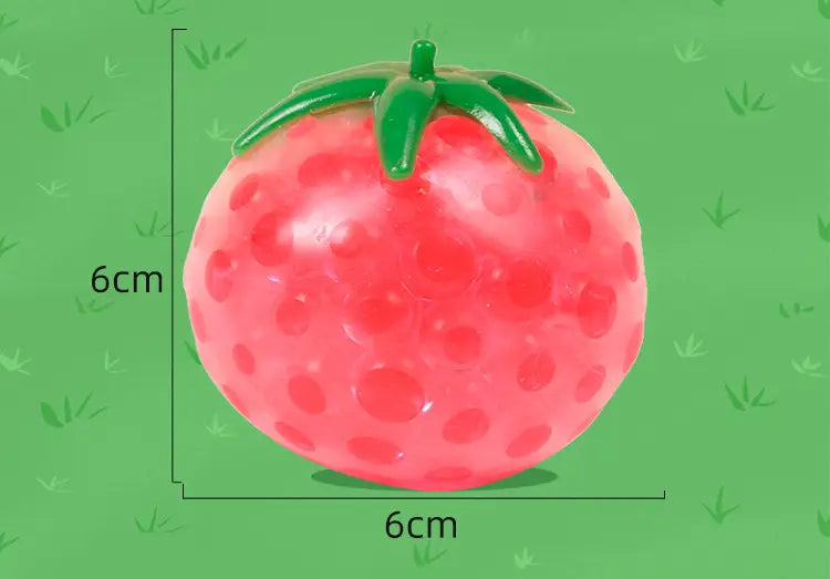 A glossy pink strawberry-shaped gel bead squishy tomato stress relief squeeze ball with a green leafy top measuring 6cm in diameter.