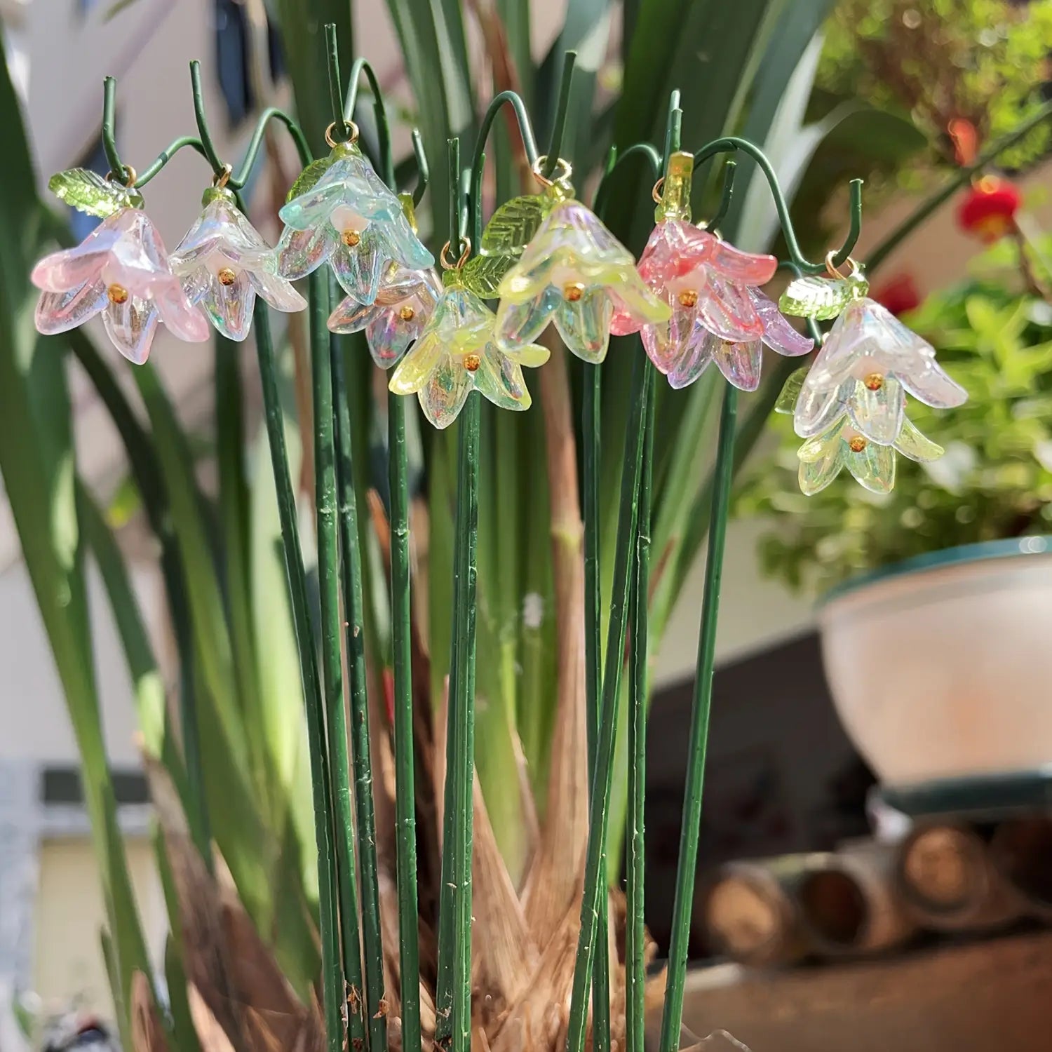 Glass lily garden stakes plant decor featuring delicate glass bellflower ornaments in pastel pink yellow and clear hues with gold centers.
