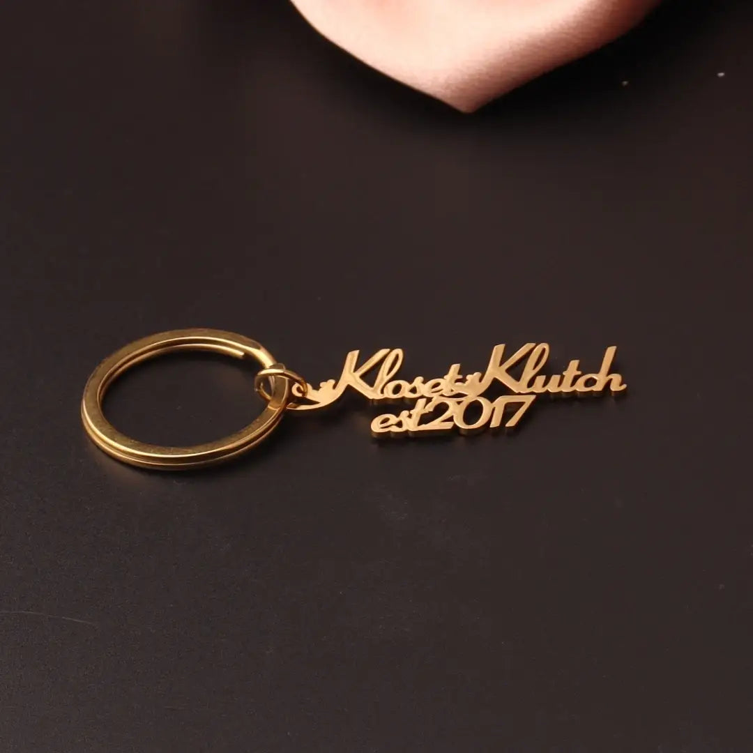 Gold-colored stainless steel custom name keychain featuring the engraved text kloset klutch est 2017 in cursive script designed as a personalized gift.