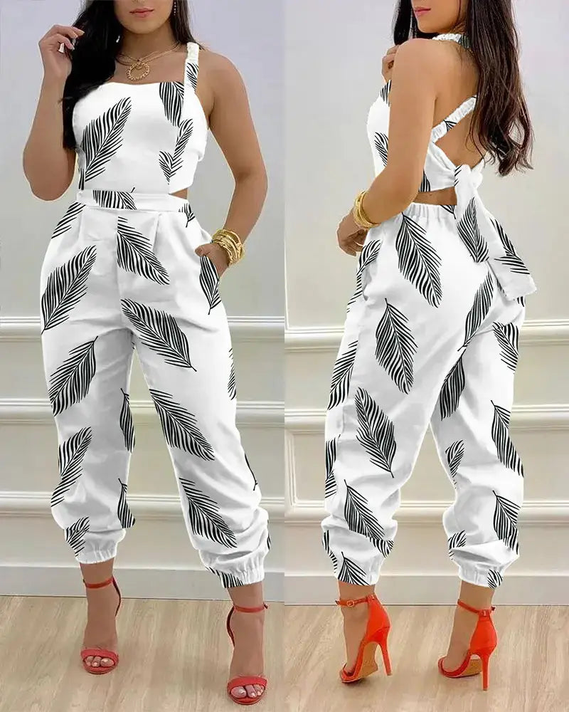 White jumpsuit with black palm leaf print and a cutout waistband designed for women summer wear.
