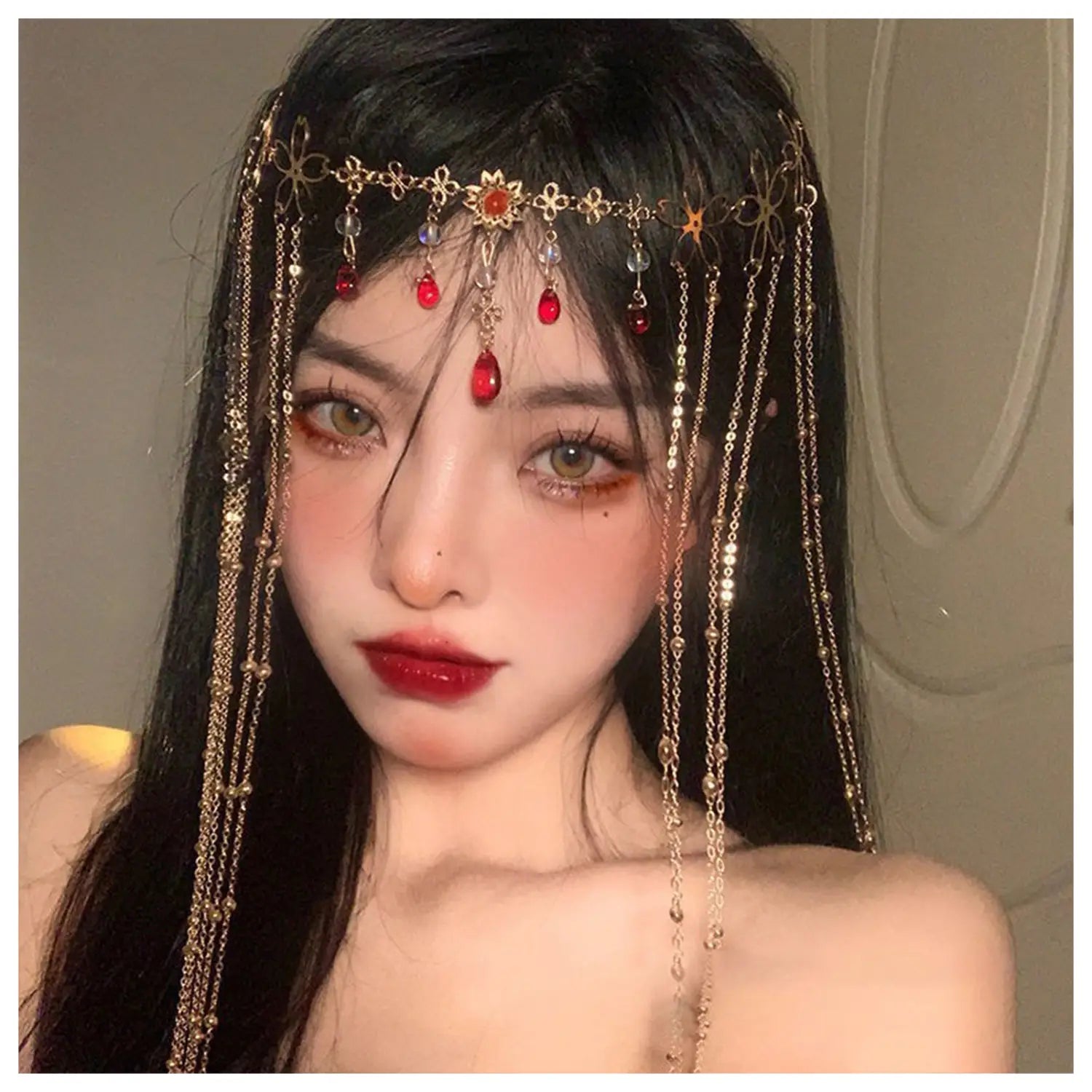 赤い宝石のゴールド前髪チェーンヘアペンダント。ゴールドトーンの精緻な花のデザインと、揺れる赤色およびクリアのビーズ、繊細なチェーンストランドが施されています。