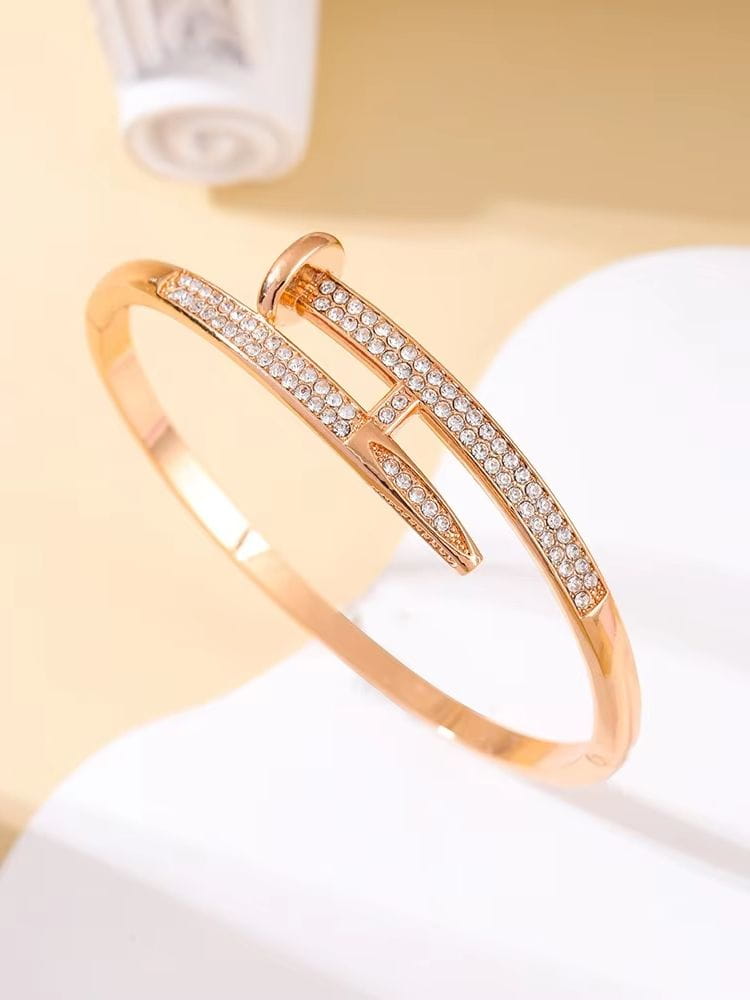 Bracelet jonc en zirconium cubique intersectant à tons dorés, à la conception moderne et élégante, présentant deux lanières ornées de rangées de cristaux transparents étincelants.
