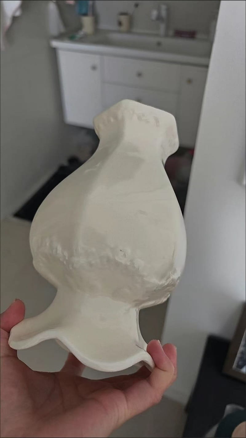 Un jarrón de cerámica moderno blanco con forma de perro, acabado liso y brillante y detalles discretos en relieve, para una decoración elegante del hogar