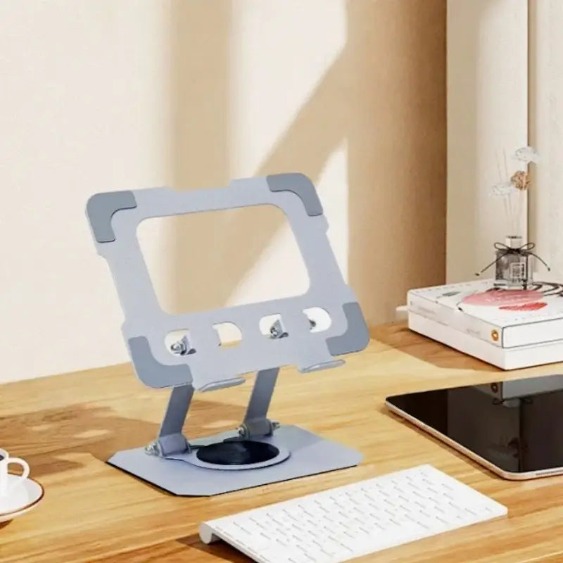 Soporte ajustable gris de metal para portátil con diseño minimalista y construcción sólida, con funcionalidad plegable ajustable con rotación de 360 grados.