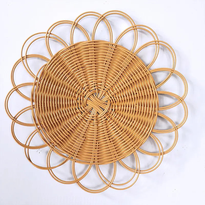 Natural-toned woven rattan flower wall hanging decor with an intricately woven circular design featuring concentric rings and an outer petal-like border.