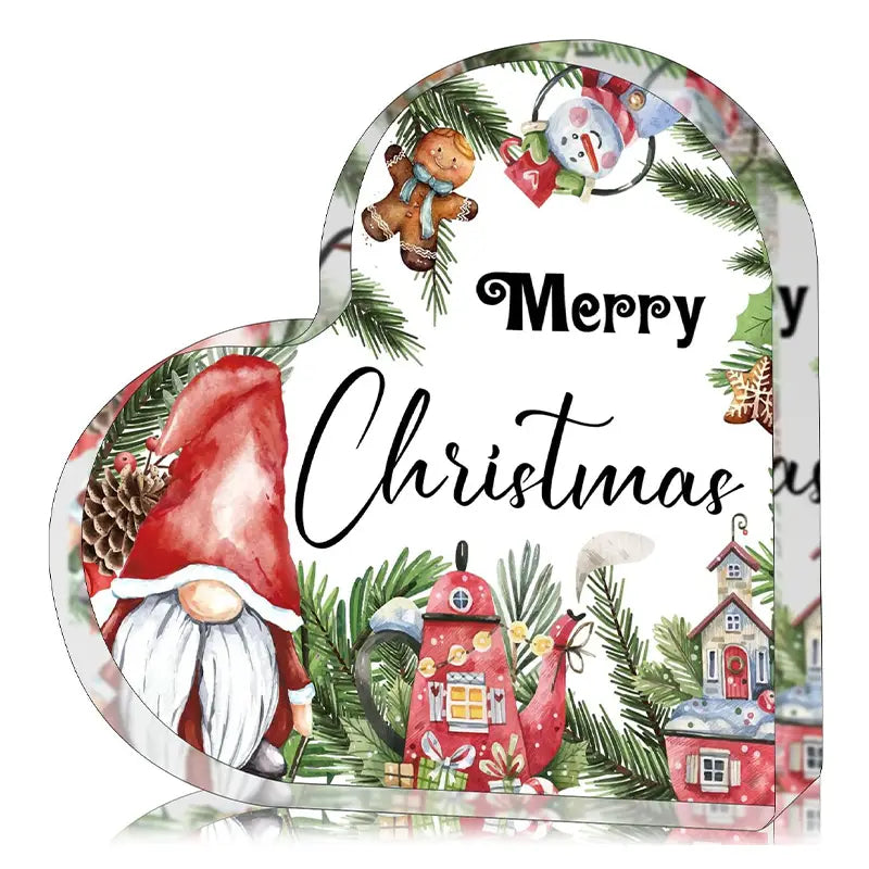 Ein Acryl-Weihnachtsherz-Ornament-Desktopständer mit einer herzförmigen Deko-Box mit Aquarell-Design: ein rot gekleideter Gnom, festliche Häuser, Tannenzweige und eine „Merry Christmas“-Schrift.