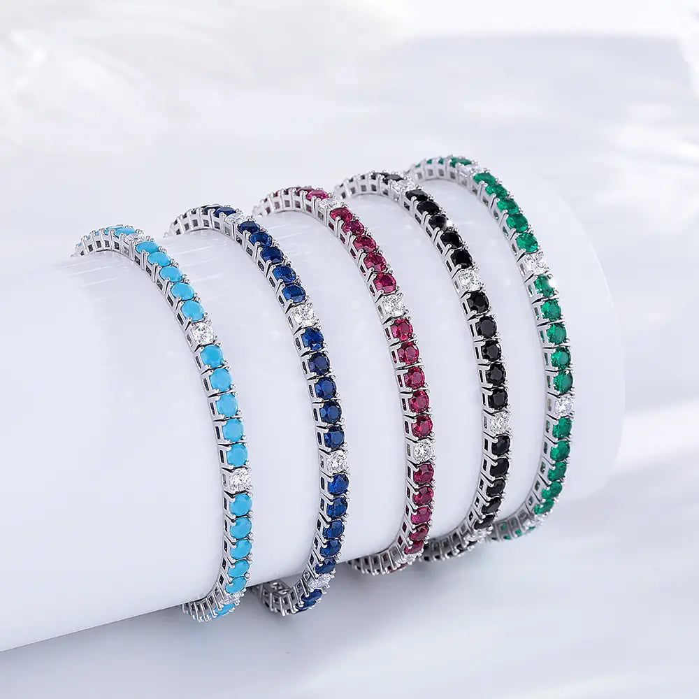 Sterling silver black cz tennis bracelet 3mm and four additional elegant tennis bracelets with silver-toned metal frames set with turquoise, sapphire, ruby, onyx, and emerald gemstones accented by clear stones.