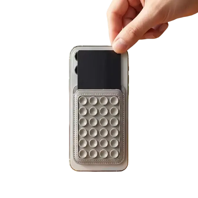 Gray leather magsafe magnetic card holder with circular pop-up dot grid folded as a phone stand seen from front