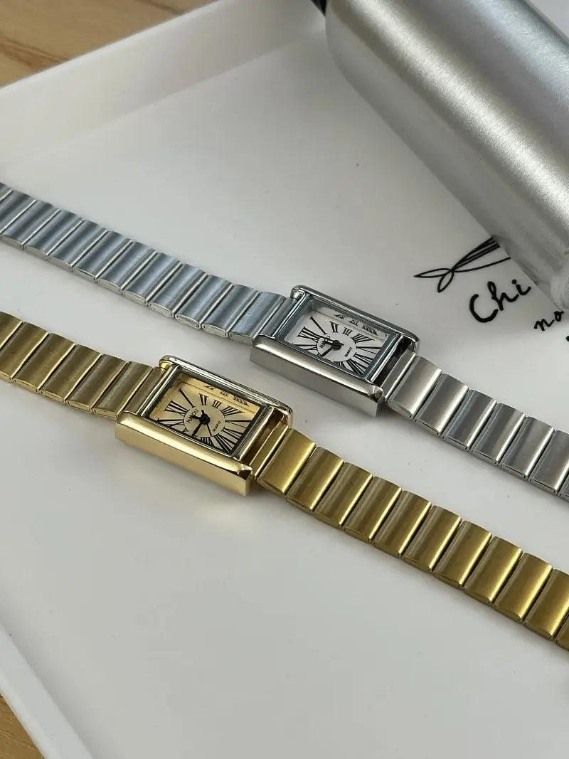 Two vintage gold and silver-tone rectangular quartz watches for women with metal bracelets and roman numeral dials.