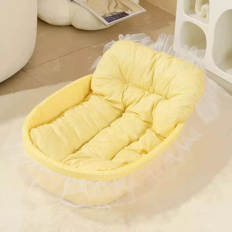 Una cama para mascotas blanda de tela acolchada amarillo pálido, con tela texturizada y ribete de encaje fruncido, diseñada como cojín estilo cuadros tipo princesa para perros pequeños