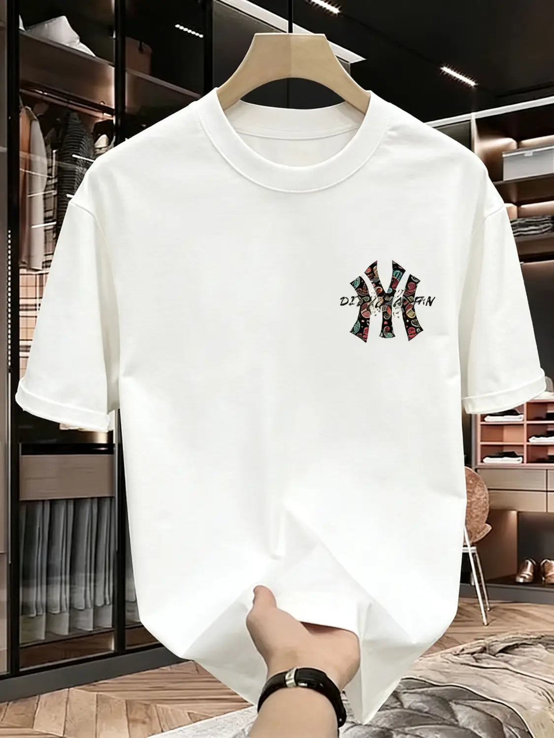 Mens summer printed graphic t shirt featuring a white short-sleeved design with colorful embroidered ny logo and text on the left chest.