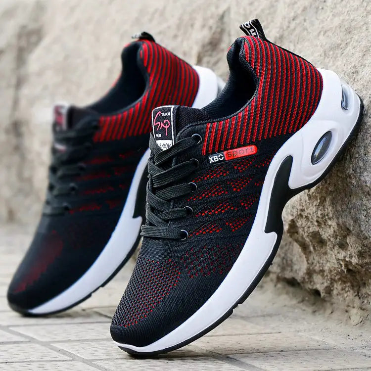 Baskets décontractées pour hommes en maille, en noir et rouge, avec des semelles blanches et une unité de coussin d’air visible, conçue pour une marche légère.