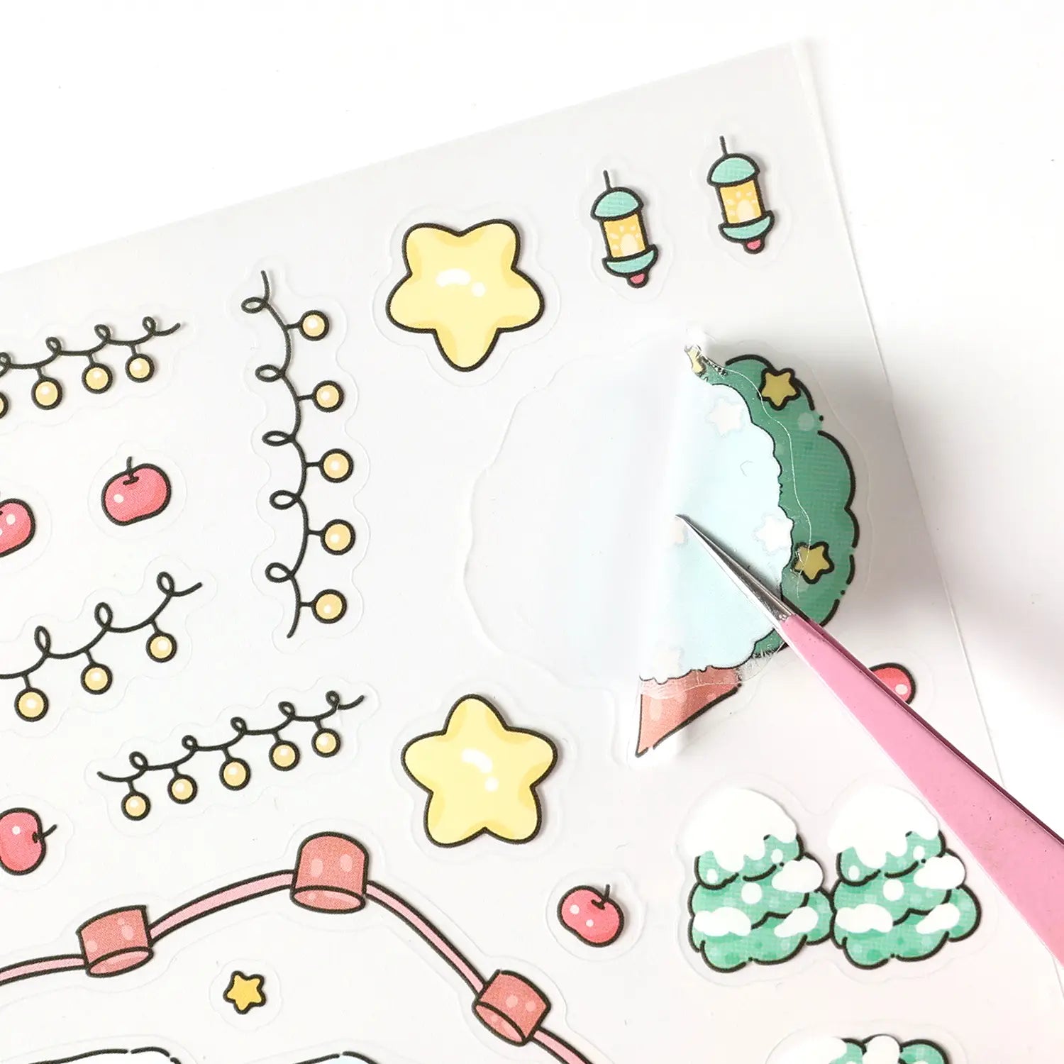Ein Bogen mit niedlichen, farbenfrohen Stickeraufklebern mit Cartoon-Sternen, Laternen, Äpfeln und schneebedeckten Bäumen aus dem Weihnachts-Kinderfilm-Sticker-Set für festliche Dekoaufkleber für das Weihnachtsjournal.