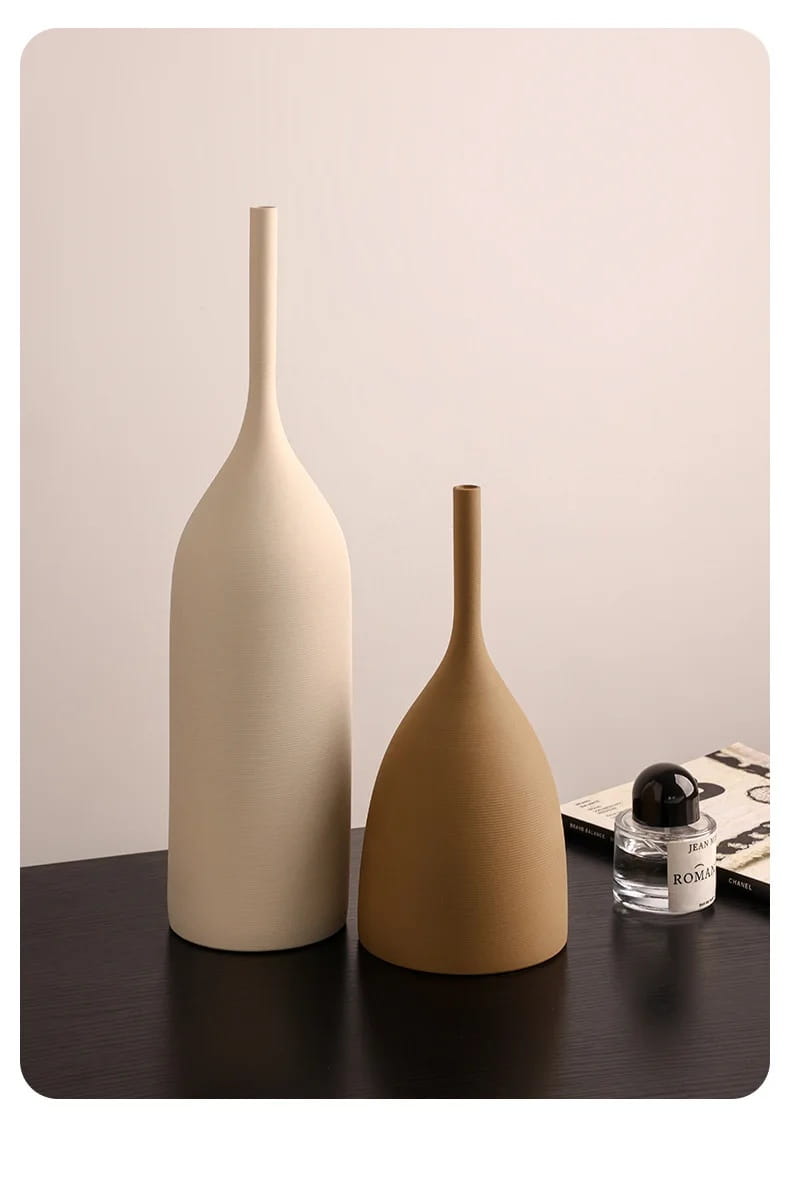Dos jarrones de cerámica minimalistas en crema blanco marfil y marrón terracota cálido, con cuellos esbeltos y acabados mate lisos, para una decoración wabi sabi.