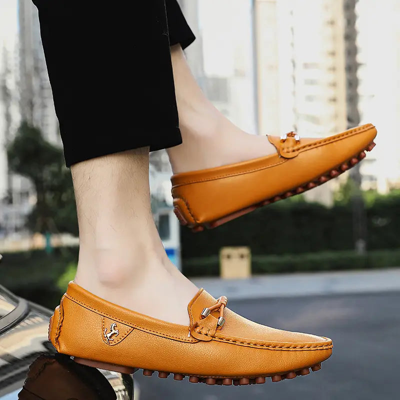 Les chaussures à enfiler habillées en cuir pour hommes se portent sans effort avec des chaussures décontractées en cuir beige, avec un design classique de mocassin, des accents métalliques à tonalité argentée et une semelle en caoutchouc texturée.