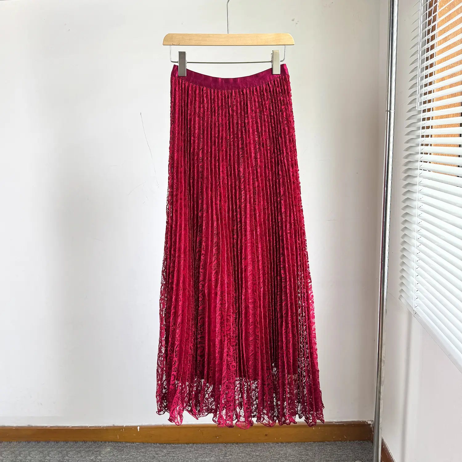 A vibrant red high waist pleated midi skirt with a velvet-like texture and delicate lace detailing along the hem designed for Y2k streetwear.