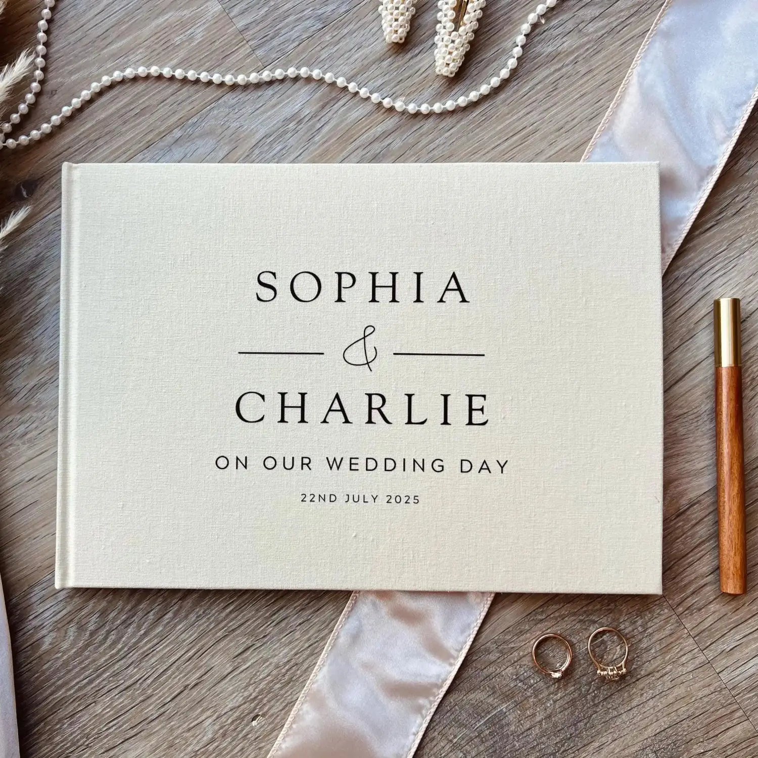 Livre d’invités de mariage en lin beige personnalisé, album Polaroid, avec une typographie noire à empattements indiquant sophia et charlie le 22 juillet 2025 lors de notre mariage.