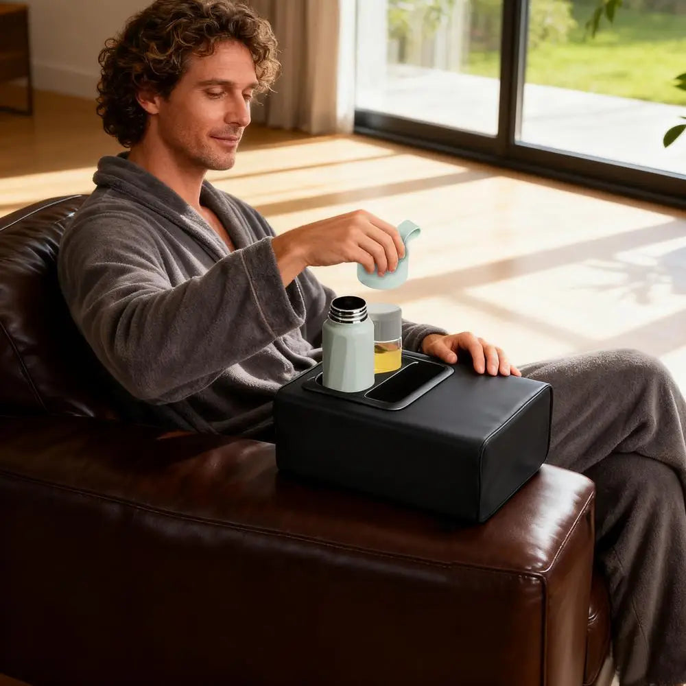 Organizador negro de cuero para consola de automóvil con portavasos integrados y bandeja de teléfono con espuma viscoelástica, diseñado como accesorio tipo otomana.
