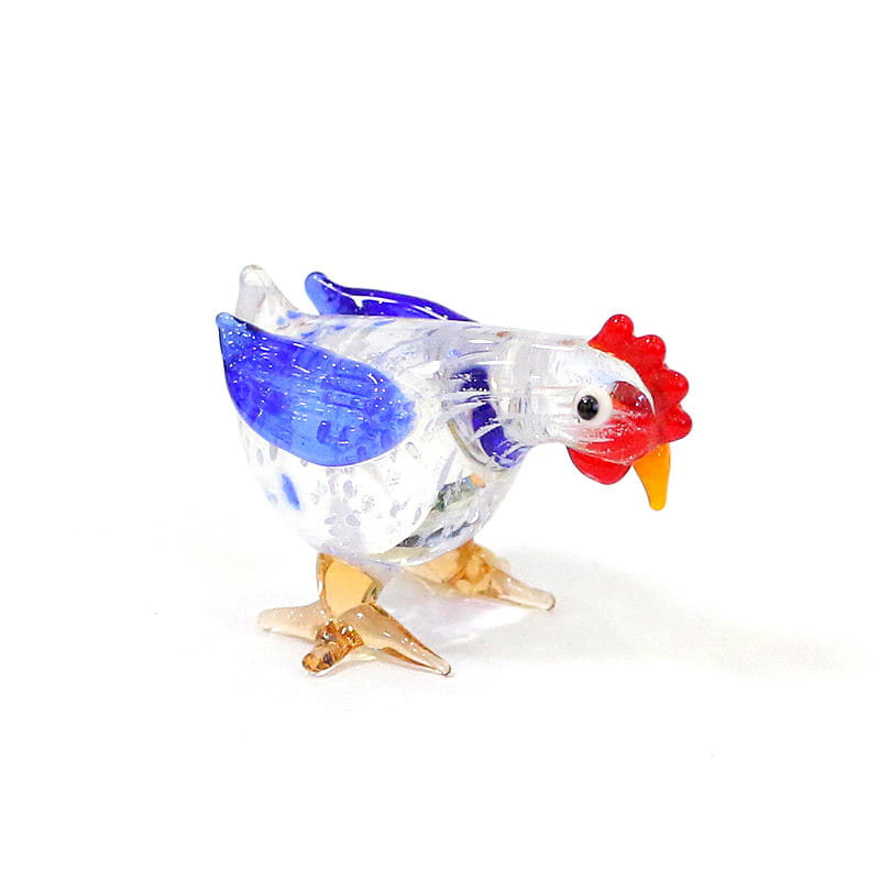 A translucent glass rooster miniature figurine with blue wings red comb and yellow beak used as an Easter ornament.