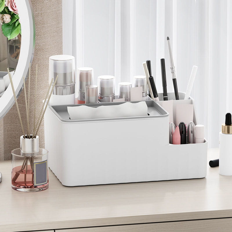 White plastic multi compartment desk organizer holding various cosmetics and brushes for makeup storage.