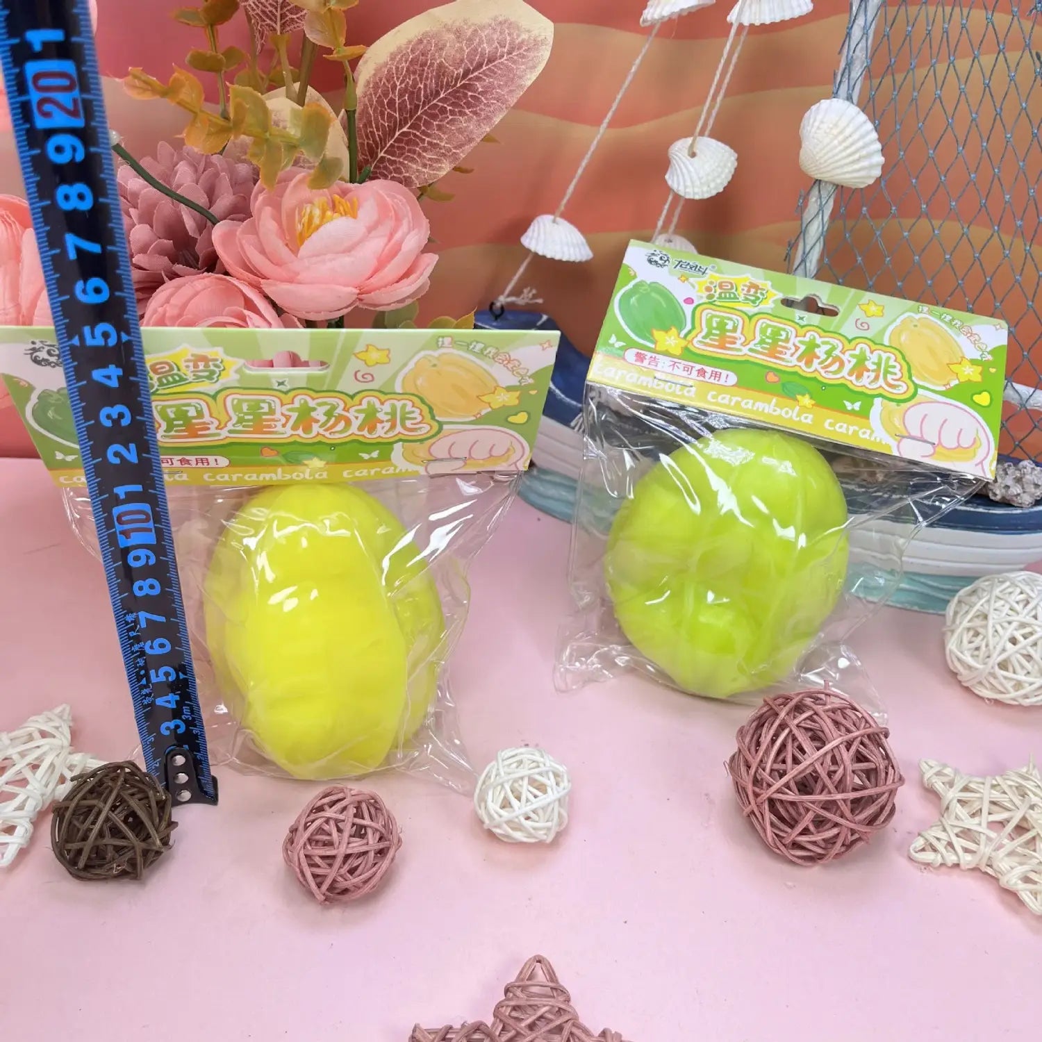 Pelotas antiestrés de juguete blando de fruta estrella que cambia de temperatura, con forma de carambola, en amarillo brillante y verde claro, envasadas en plástico transparente con etiquetas coloridas.
